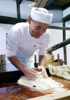 白下糖の「研ぎ」の作業に精を出す職人＝上板町の岡田製糖所