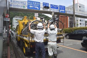 放置自転車を撤去する県職員＝徳島市新町橋２