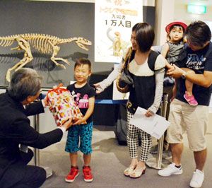 来場１万人目の記念品を受け取る翔大君（左から２人目）＝徳島市の県立博物館