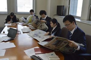 新聞に目を通し、課題に取り組む新入社員ら=徳島市の四国放送本社