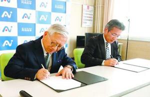 協定書に署名する松重学長(左)と寺沢校長=阿南市の阿南高専