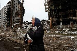 　４月５日、ウクライナ・ボロディアンカで、ロシア軍に砲撃された建物の近くを歩く女性（ロイター＝共同）