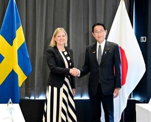 　スウェーデンのアンデション首相（左）と握手する岸田首相＝２９日、スペイン・マドリード（代表撮影・共同）
