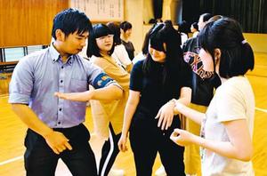 署員(左端)から護身術を学ぶ参加者=徳島市の県立総合看護学校