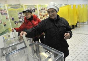 　ウクライナ南部クリミア半島のロシア編入の是非を問う住民投票で投票用紙を投じる女性ら＝２０１４年３月、シンフェロポリ（タス＝共同）