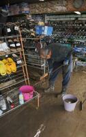 　大雨の影響で店内にたまった泥を掃除する男性＝１１日午前、青森県鰺ケ沢町