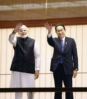 　迎賓館の池のコイに餌を与え、笑顔を見せる岸田首相（右）とインドのモディ首相＝２４日午後、東京・元赤坂