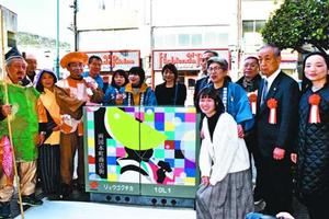 トランスボックスにプリントされた阿波踊りアートの完成を祝う関係者=徳島市両国本町1