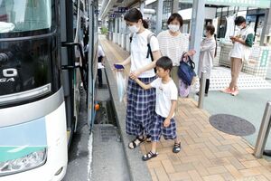 関西方面に向かう高速バスに乗り込む家族連れ=徳島駅前