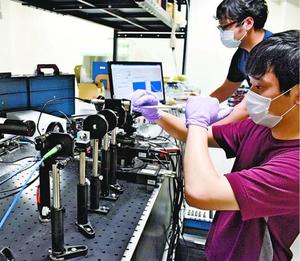 バイオセンサーを使って実験を行う大学院生ら=徳島市南常三島町2の徳島大ポストLEDフォトニクス研究所