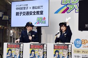 警察官の制服姿で交通安全を訴える声優の中村繪里子さん(右)=徳島市の東新町商店街