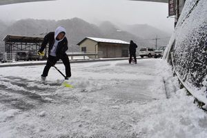 店舗駐車場の雪かきをする住民＝午前１０時ごろ、三好市池田町イタノ