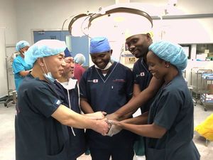 手術を無事終え、握手を交わす（左から）江川医師、松村医師と現地の医師ら＝ルサカ市のザンビア大学付属教育病院