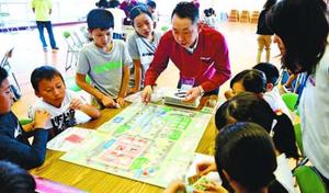ボードゲームを通じ、環境に配慮した会社経営について学ぶ児童=徳島市の南井上小