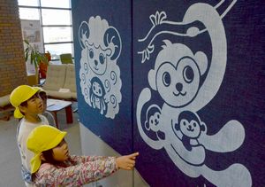 えとをあしらった藍染のタペストリーに見入る子どもたち＝徳島市立木工会館