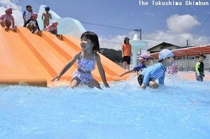 幼児用プールの滑り台で遊ぶ子ども＝徳島市のワークスタッフ田宮プール