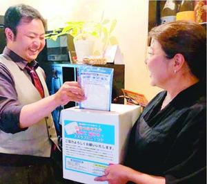 福祉施設に寄付するため、マスクを集める瀧本さん(右)=徳島市栄町1の「しなり」