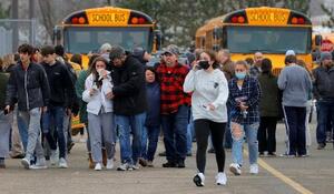 　１１月３０日、銃撃事件があった米中西部ミシガン州オックスフォードの高校付近から離れる親子ら（Ｅｒｉｃ　Ｓｅａｌｓ―ＵＳＡ　ＴＯＤＡＹ　ＮＥＴＷＯＲＫ／ロイター＝共同）