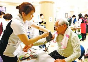 看護師(左)に血圧を測ってもらう男性=阿南市宝田町の阿南医療センター