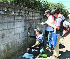 ブロック塀の耐震性調査を行う建築士ら=2019年9月、小松島市和田島町