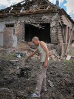 　ロシア軍のロケット弾が落ちた場所を示す地元住民＝２４日、ウクライナ東部ドネツク州（ＡＰ＝共同）