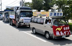街宣車の先導で、安保法案の反対デモに出発するダンプカー＝１３日、徳島市津田海岸町
