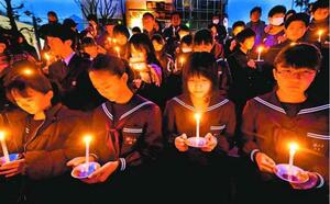 参加者の持つろうそくにともされた希望の灯り=徳島市の新町橋東公園