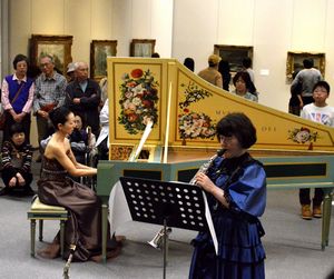 西洋絵画が並ぶ会場で優雅な演奏を聴く来場者＝徳島市の県立近代美術館