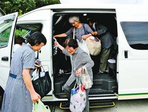 コミュニティーバスから降りる乗客=徳島市の上八万コミュニティセンター