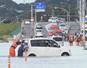 道路が冠水したため立ち往生した軽ワゴン車を移動させる消防署員ら＝２０日午後５時ごろ、徳島市八万町寺山