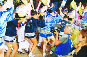 ゑびす連の踊りを撮影する亭田さん(前列右から2番目)=徳島市の新町橋東おどり広場