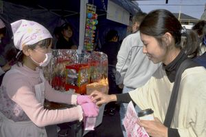 「１００円商店街」に出店し、ポップコーンを販売する児童（左）＝鳴門市撫養町南浜の大道商店街