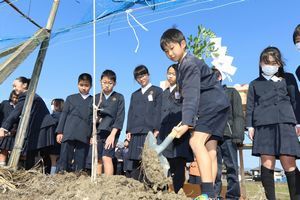 ブドウの苗木を植樹する児童ら＝吉野川市川島町学のブドウ畑