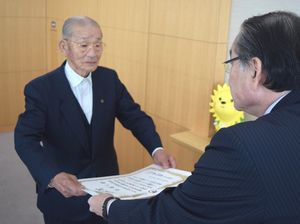 交通遺児への長年の寄付をたたえる表彰状を、岩浅市長（右）から受け取る谷さん＝阿南市役所